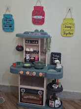 Child-sized play kitchen with toy food and utensils